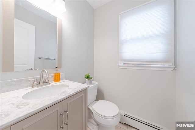 bathroom featuring toilet, vanity, a baseboard heating unit, and plenty of natural light