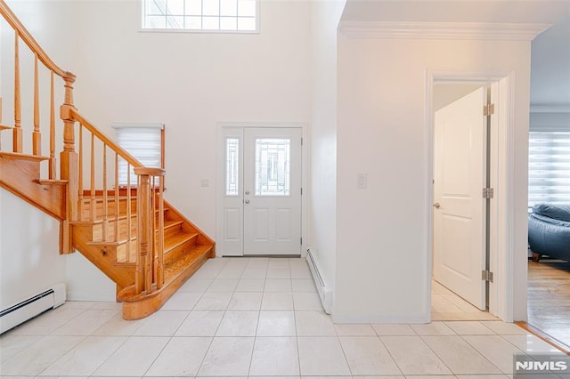 entrance foyer with a baseboard radiator, light tile patterned floors, and crown molding