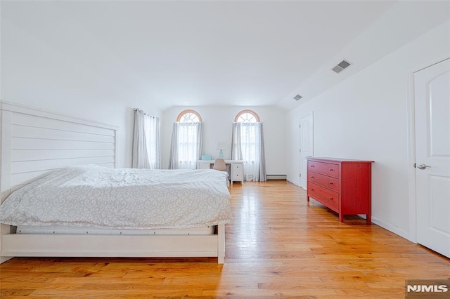 bedroom featuring a baseboard radiator and light hardwood / wood-style flooring