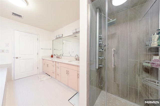 bathroom featuring vanity, tile patterned flooring, and walk in shower