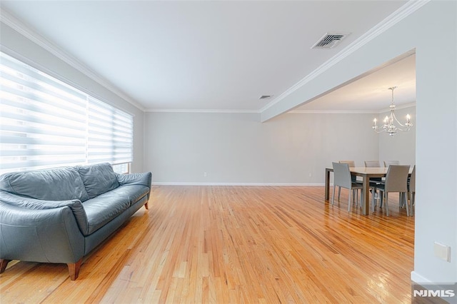 sitting room featuring an inviting chandelier, ornamental molding, and light hardwood / wood-style flooring