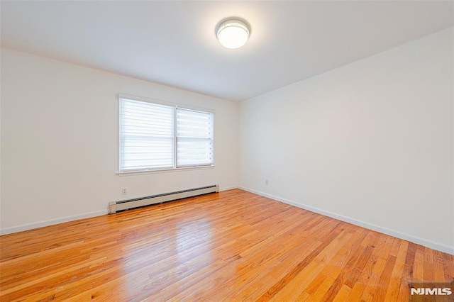 empty room featuring light hardwood / wood-style floors and a baseboard radiator