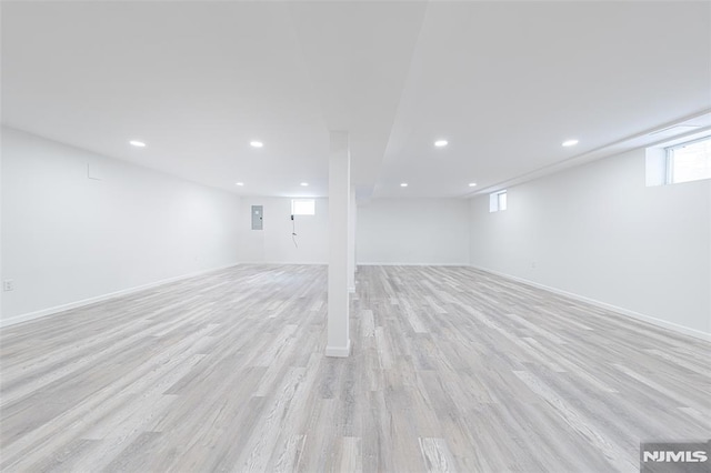 basement featuring light hardwood / wood-style floors and electric panel