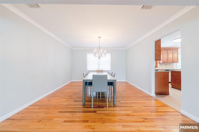 dining space featuring crown molding, light hardwood / wood-style flooring, and a notable chandelier