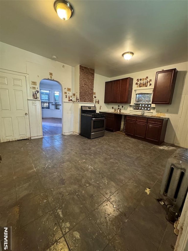 kitchen featuring dark brown cabinetry, sink, and stainless steel range oven