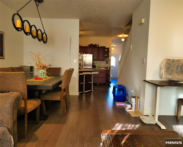 dining area featuring dark hardwood / wood-style flooring and a textured ceiling