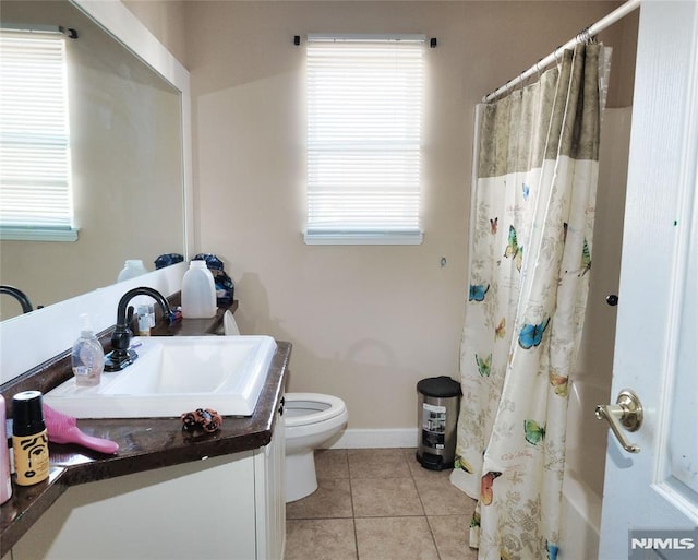 bathroom with toilet, vanity, and tile patterned floors