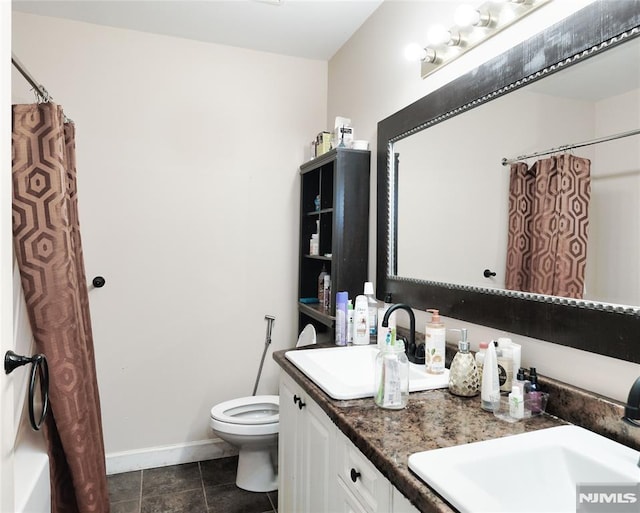 bathroom featuring tile patterned floors, vanity, and toilet