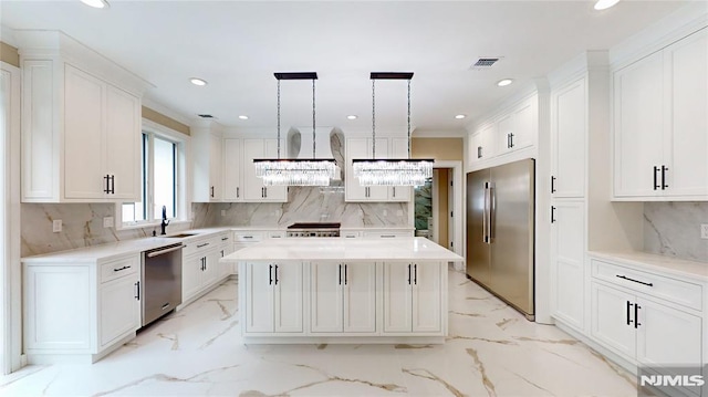 kitchen featuring pendant lighting, a center island, white cabinets, and appliances with stainless steel finishes