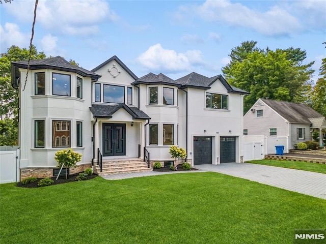 view of front of property with a garage and a front lawn