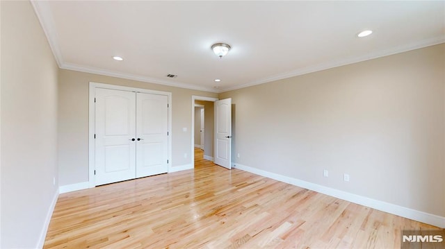 unfurnished bedroom with a closet, light hardwood / wood-style floors, and ornamental molding