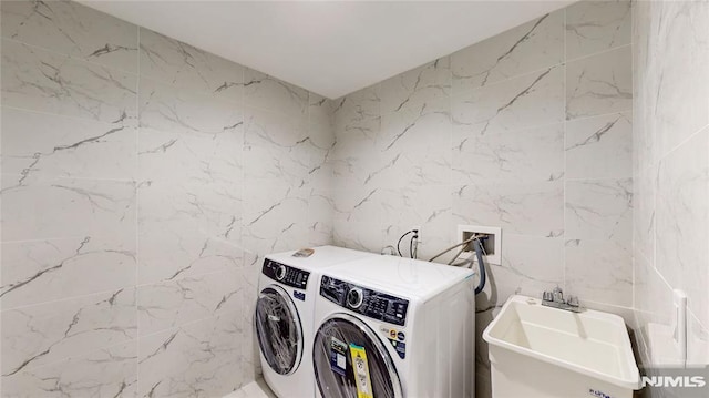 clothes washing area with independent washer and dryer and sink