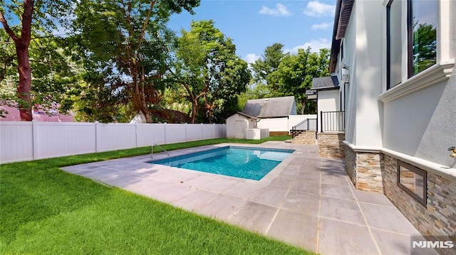 view of pool with a patio area and a storage shed