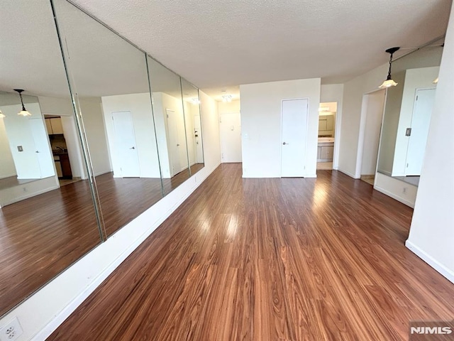 empty room with dark hardwood / wood-style flooring and a textured ceiling