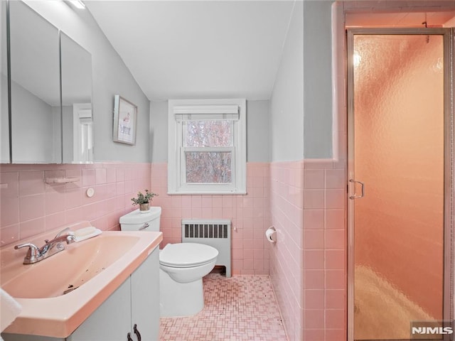 bathroom featuring toilet, tile patterned flooring, radiator, an enclosed shower, and vanity