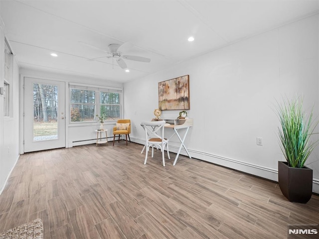 unfurnished room with ceiling fan, baseboard heating, and light hardwood / wood-style floors