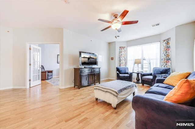 living room featuring ceiling fan and light wood-type flooring