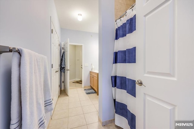 bathroom featuring tile patterned flooring, walk in shower, and vanity