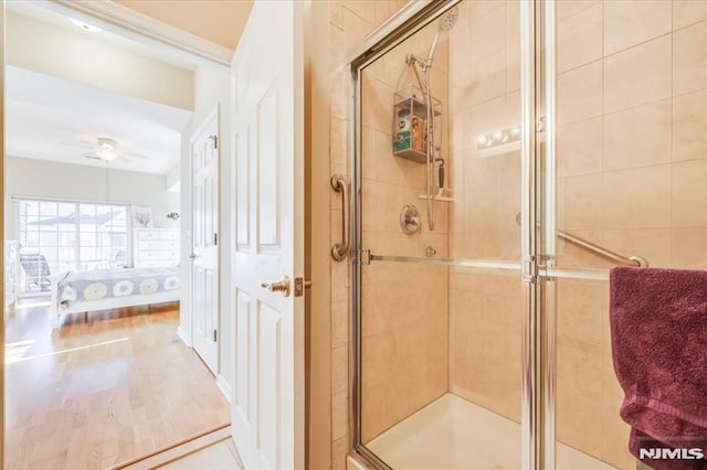 bathroom featuring ceiling fan, hardwood / wood-style flooring, and walk in shower