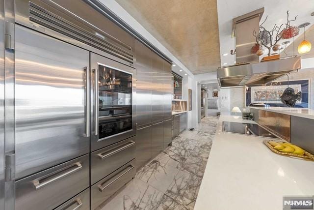 kitchen featuring stainless steel built in refrigerator, black electric stovetop, pendant lighting, and ventilation hood