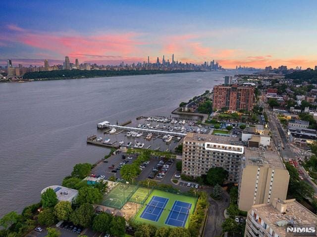 aerial view at dusk featuring a water view