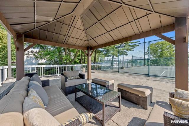 view of patio / terrace featuring a gazebo, tennis court, and an outdoor living space