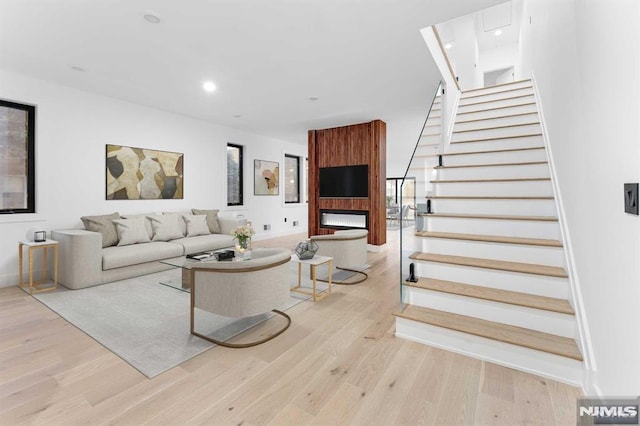 living room with a large fireplace and light hardwood / wood-style flooring