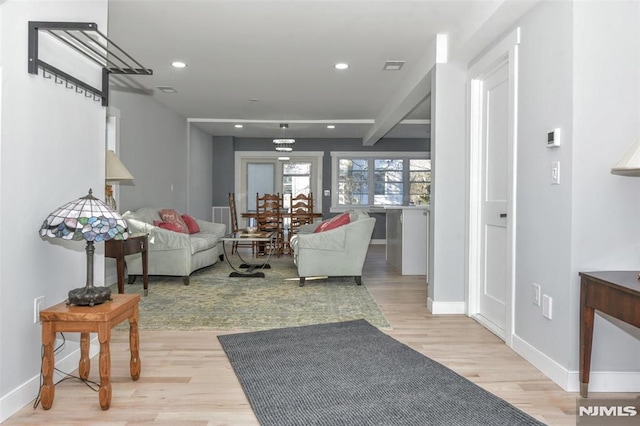 living room with beam ceiling and light hardwood / wood-style floors