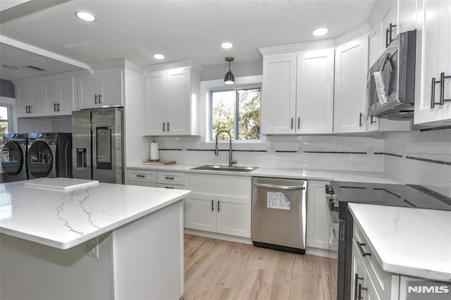 kitchen with white cabinetry, independent washer and dryer, stainless steel appliances, and sink