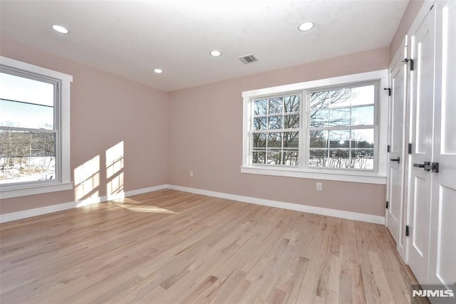 unfurnished room featuring plenty of natural light and light hardwood / wood-style floors