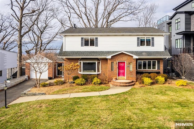 view of front property with an outbuilding, a garage, and a front yard