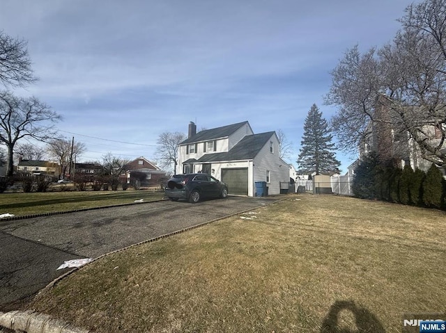 view of side of home with a garage and a lawn