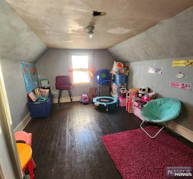 recreation room with dark wood-type flooring and vaulted ceiling