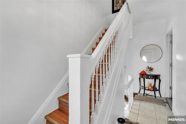 staircase featuring tile patterned floors and crown molding