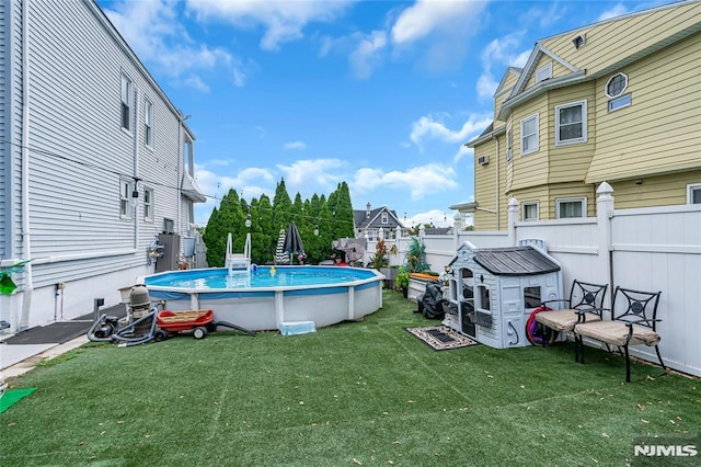 view of pool featuring a lawn and a storage shed