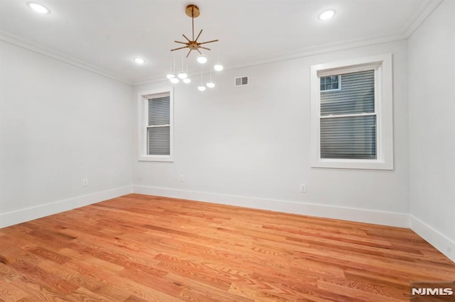 spare room featuring ornamental molding and light hardwood / wood-style flooring