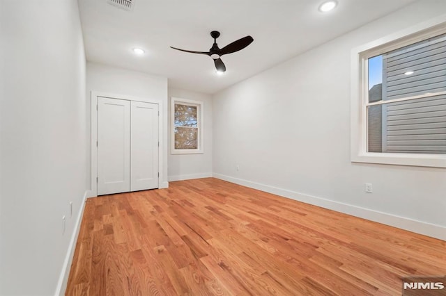 unfurnished bedroom with ceiling fan, light hardwood / wood-style floors, and a closet