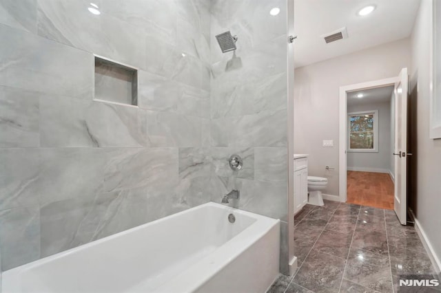 full bathroom featuring toilet, tiled shower / bath combo, and vanity