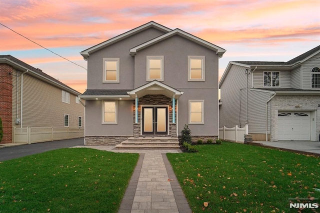 front facade featuring a lawn and a garage