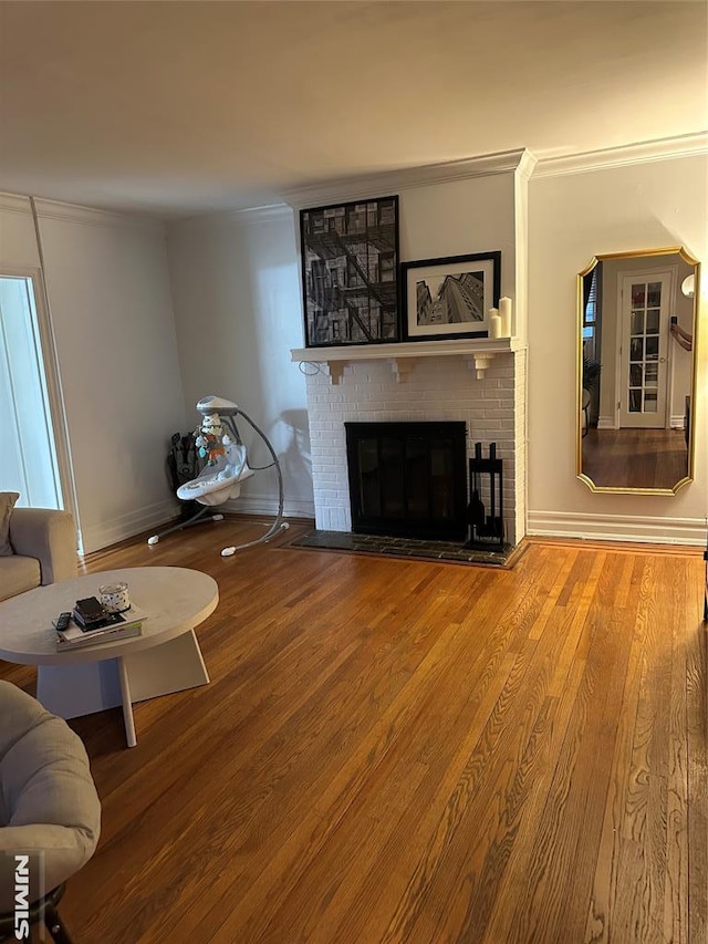 living room featuring a fireplace, ornamental molding, and hardwood / wood-style flooring