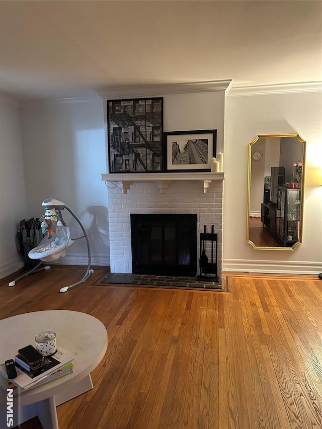 unfurnished living room featuring wood-type flooring, a fireplace, and ornamental molding