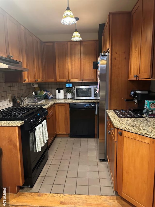 kitchen with black appliances, light stone countertops, light tile patterned floors, decorative light fixtures, and tasteful backsplash