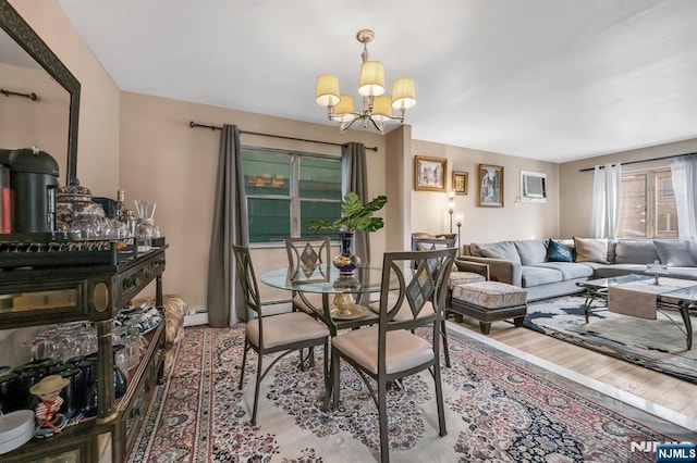 dining area featuring a baseboard heating unit, hardwood / wood-style floors, and a chandelier