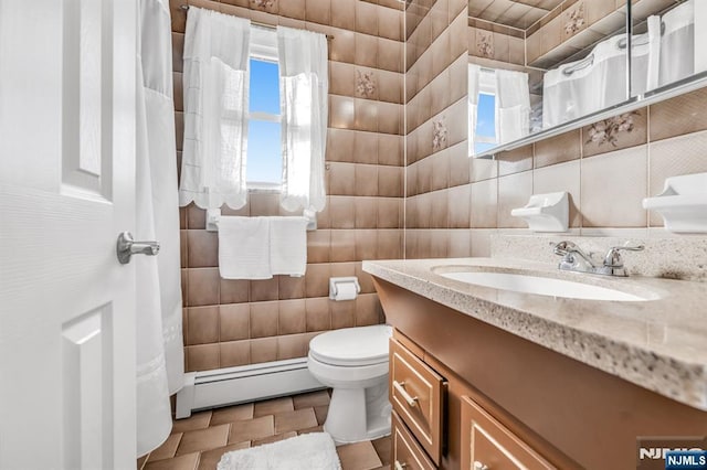 bathroom featuring tile walls, vanity, a baseboard radiator, and toilet