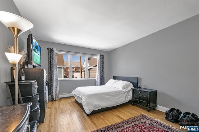 bedroom featuring hardwood / wood-style floors and baseboard heating