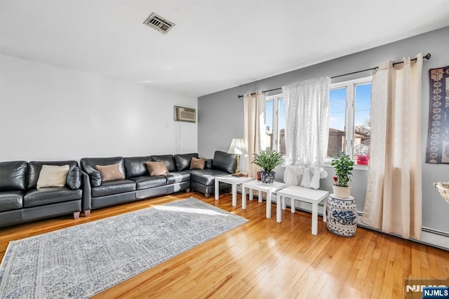 living room with wood-type flooring and a wall unit AC