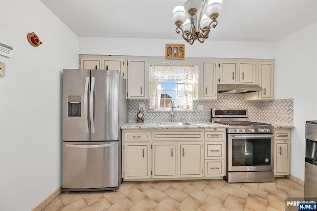 kitchen featuring sink, appliances with stainless steel finishes, tasteful backsplash, light stone countertops, and cream cabinetry