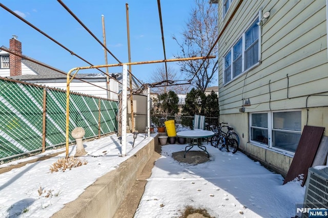 snow covered patio with central AC unit