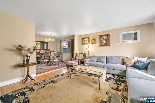 living room with hardwood / wood-style floors, a notable chandelier, and an AC wall unit