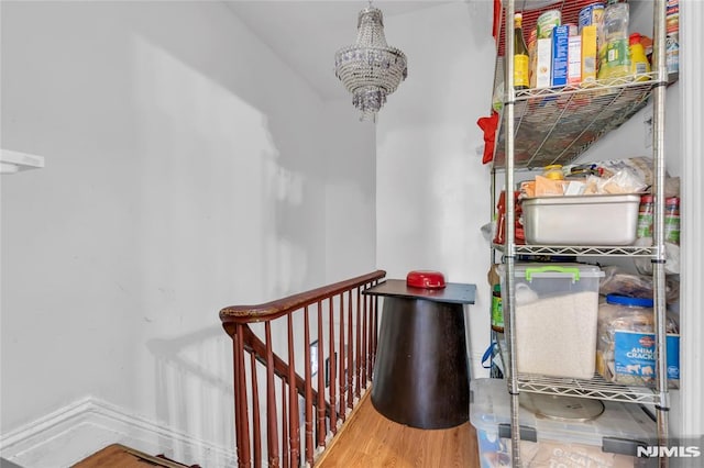 stairs with a notable chandelier and wood-type flooring